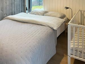 a bedroom with a white bed with a crib at 10 person holiday home in Lindesnes in Spangereid