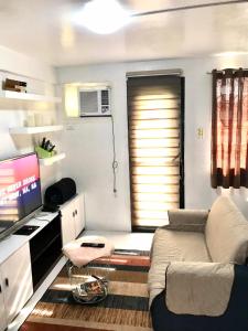 a living room with a couch and a flat screen tv at The Escape Pad 3 in Manila