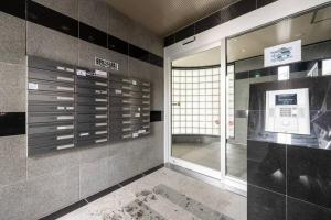 a room with a wall of lockers in a building at Shizuk +O Stay 2 in Kita-sanjō
