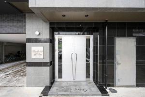 a white door on a building with a sign on it at Shizuk +O Stay 2 in Kita-sanjō +58 photos