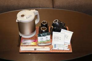 a table with a coffee pot and books on it at ホテルバリアンリゾート千葉中央 in Chiba