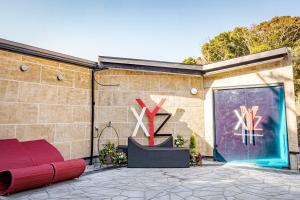 XYZ Private Spa and Seaside Resort في شيراهاما: مبنى من الطوب مع أريكة حمراء وباب زجاجي