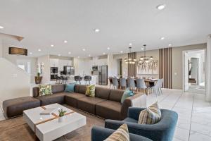 uma sala de estar e cozinha com um sofá e uma mesa em Modern House with Pool, Theater, Game Room, near Disney - 2316 em Loughman