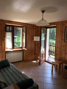 1 dormitorio con paredes de madera, 1 cama y ventanas en Appartamento Saint-Jacques des Allemands, en Champoluc