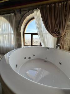 a large bath tub in a room with a window at Bedrock Cave Hotel in Goreme