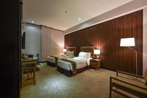 a hotel room with two beds and a desk at 1825 Gallery Hotel in Melaka