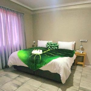 a bedroom with a green bed with two cats on it at OR Tambo Rudman B self-Catering Home L2 in Boksburg