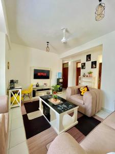 een woonkamer met een bank en een tafel bij Ample home 2 bedroom apartment in Mombasa