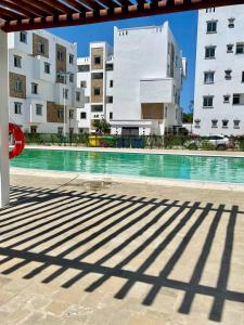 a swimming pool in front of a building at Ample home 2 bedroom apartment in Mombasa