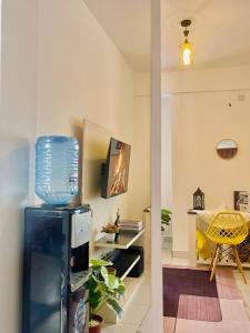 een woonkamer met een koelkast en een televisie bij Ample home 2 bedroom apartment in Mombasa
