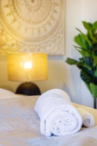 a white towel sitting on top of a bed at Central Oasis: Charming Studio with Backyard in Christchurch