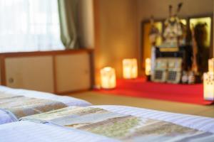 Koyanagichō的住宿－１組限定　家族連れ歓迎　松本城徒歩15分　無料駐車場2台有，坐在房间床边的书