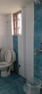 uma casa de banho com um WC e uma janela em Suburbs Holiday Home em Dabolim