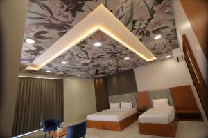 奇陶尔加尔Hotel Pride Of Chittor的客房设有两张床和鲜花天花板。