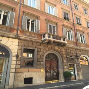 een gebouw met een houten deur en een balkon bij QT Suites Roma in Rome