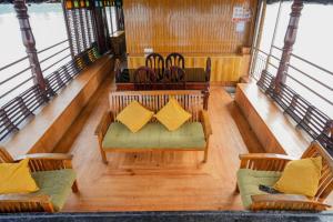 an upper deck of a boat with couches and chairs at St. Mary Houseboat in Kumarakom