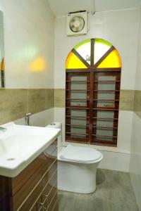 a bathroom with a sink and a toilet and a window at St. Mary Houseboat in Kumarakom