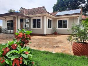 uma casa com painéis solares no telhado em Ellyz Home Stay em Moshi