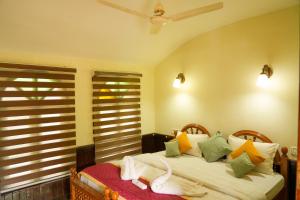 a bedroom with a bed and a window with shutters at St. Mary Houseboat in Kumarakom