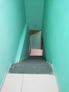 a small room with a pink floor and a blue wall at A Private Room With Terrace in Ahmedabad