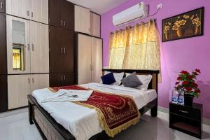 a bedroom with a large bed with purple walls at S V IDEAL HOMESTAY -2BHK SERVICE APARTMENTS-AC Bedrooms, Premium Amities, Near to Airport in Tirupati