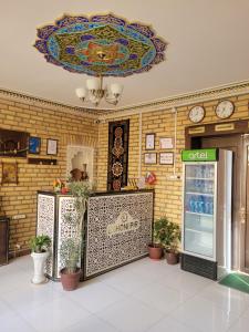 ein Gebäude mit einer Lobby, an deren Wand eine Uhr hängt in der Unterkunft ESHONI PIR Boutique in Buxoro