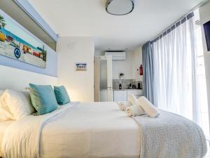 a bedroom with a large white bed with a window at Blue Serenity by Hello Homes Sitges in Sitges