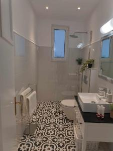 a white bathroom with a sink and a toilet at Andriani Apartment in Zakynthos