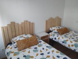 2 camas individuales sentadas una al lado de la otra en una habitación en Apartamento Cadi, en Suances