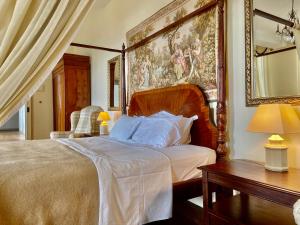 a bedroom with a bed and a painting on the wall at Chateau la Bainerie in Tiercé