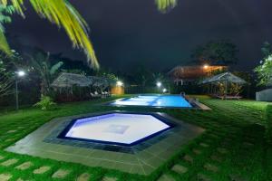 a swimming pool in the middle of a yard at night at The Hideout Sigiriya in Sigiriya