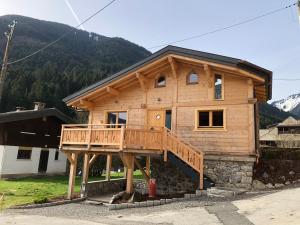 duży drewniany dom z dużym tarasem w obiekcie Chalet cosy et moderne vue montagnes w mieście Seytroux