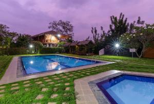 a house with two swimming pools in the yard at The Hideout Sigiriya in Sigiriya