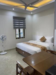 um quarto com 2 camas, uma mesa e uma ventoinha em Mimi Housing em Hanói