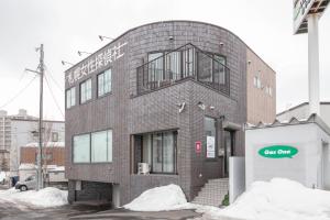 ein rotes Backsteingebäude mit einem Schild darauf in der Unterkunft ROADSIDE House in Sapporo