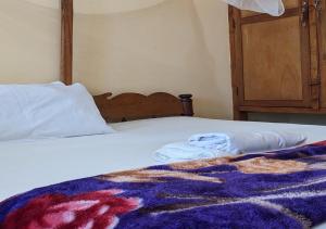 Una cama con una manta y dos toallas. en Beach hote, en Tanga