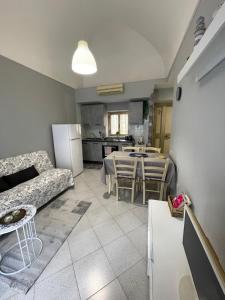 a living room with a couch and a table and a kitchen at Ninni’& Nanna’ in Cetara