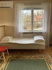 łóżko w pokoju z oknem w obiekcie Solvillan w mieście Blankaholm