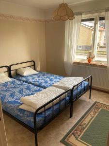 1 dormitorio con 2 camas y ventana en Solvillan en Blankaholm