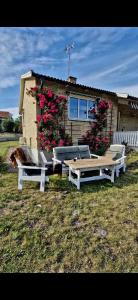 Deux tables de pique-nique devant une maison fleurie dans l'établissement Solvillan, à Blankaholm