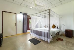 a bedroom with a canopy bed in a room at The Hideout Sigiriya in Sigiriya