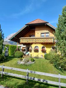 a wooden house with a fence in front of it at Haus Eder in Ramsau am Dachstein