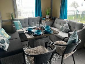 uma sala de estar com uma mesa e um sofá em Luxe Stacaravan Albatros - 51 em Bredene