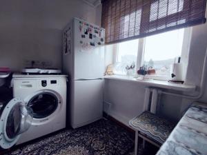 eine Küche mit einer Waschmaschine und einem Fenster in der Unterkunft Dadow Cozy House in Naryn