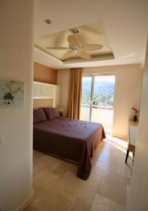 een slaapkamer met een bed en een plafondventilator bij 7 Gocek Royal in Belenpınar