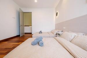 布城的住宿－3StoreyFamilyFriendly LakeVilla@Putrajaya@BathTub，白色客房的两张床,配有蓝色枕头