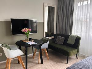 ein Wohnzimmer mit einem Tisch, einem Stuhl und einem Sofa in der Unterkunft Flowerbed in Voorhout