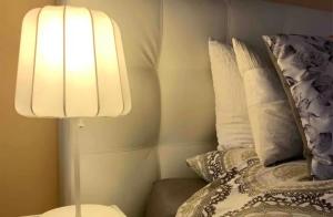 a lamp sitting next to a bed with pillows at Hemels logeren LUXURY LOFT Zutphen in Zutphen
