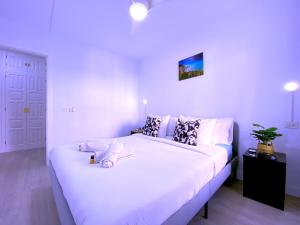 a bedroom with a large bed with white sheets and pillows at Tropicalidays Sunset Palm in Costa Del Silencio +43 photos