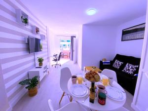 a white living room with a table and chairs at Tropicalidays Sunset Palm in Costa Del Silencio